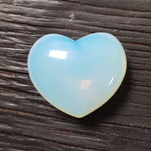 Opalite Heart, translucent pale blues, on a dark wooden board