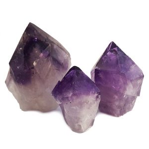Three descending sizes of Amethyst Cut Points - purple points with a white/grey base - on a white background