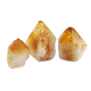 Three descending sizes of Citrine Cut Points - orange points with a grey/white colour at the base - on a white background