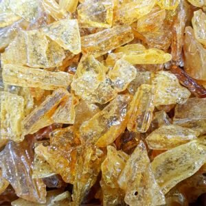Close up of Amber Columbia - pale yellow slightly translucent stone with a rough surface - in a pile