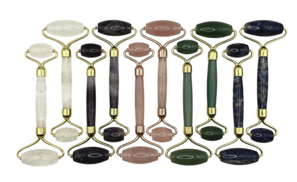 Selection of Massage Rollers - clear, pink, green and blue with gold hardware - on a white background