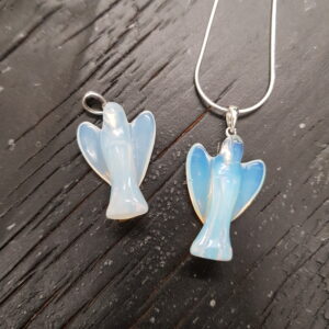 Two Opalite angel pendants - pearlescent blue stone with silver tops and chain - on a dark wooden board