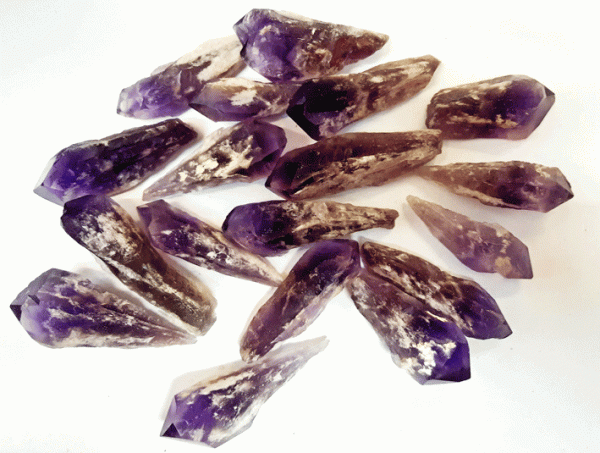Pile of Amethyst Flame Points (Mini) - purple points with rough white and translucent tails - on a white background