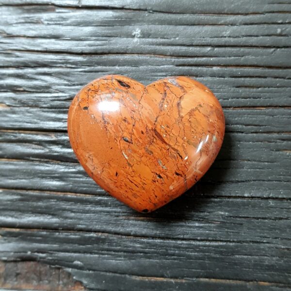 Brecciated Jasper Heart, red with black and white veins, on a dark wooden board