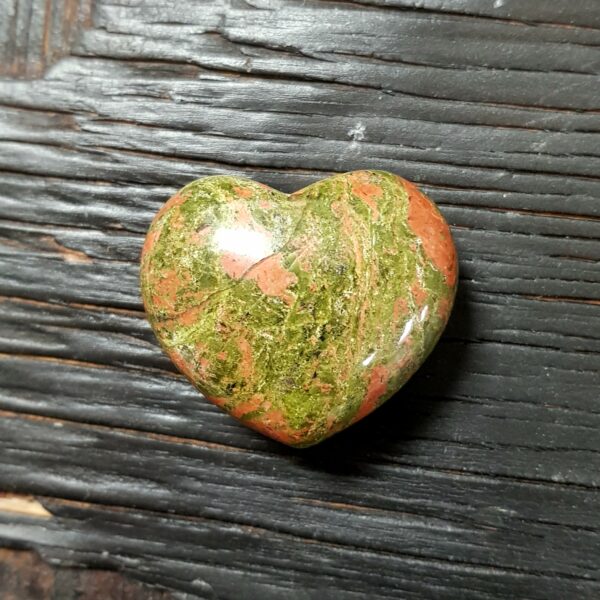 Unakite Heart, green with pink clouds, on a dark wooden board