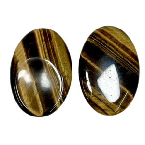 Two Tiger Eye Thumb Stones - gold with brown and black banding - on a white background