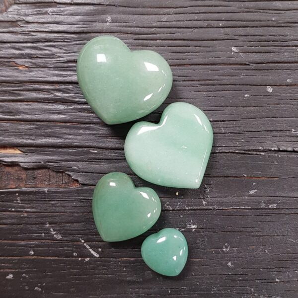 Aventurine heart selection, green opaque in 4 descending sizes, on a black wooden board