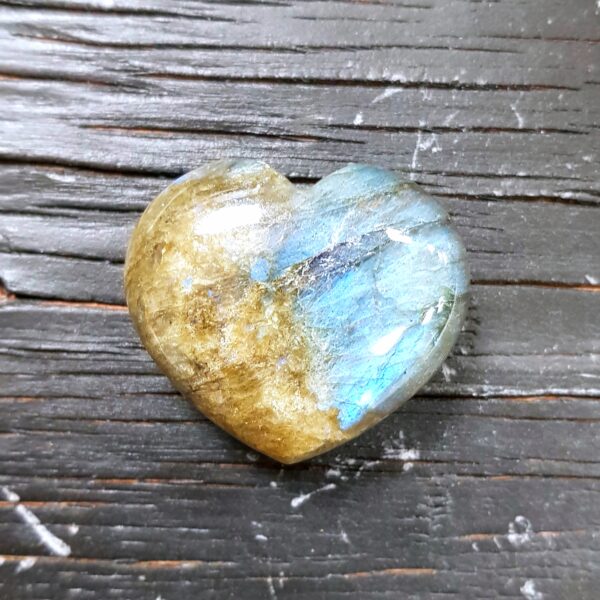 Labradorite Heart, green with a brilliant blue flash, on a black wooden board