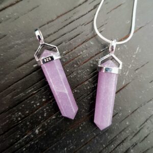 Two Lepidolite Double Terminated points (pale purple facets points at both ends), on a silver chain, on a dark wooden board