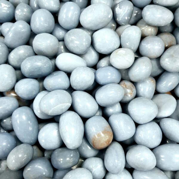 Close up of Angelite tumble stone, pale blue oval stones.