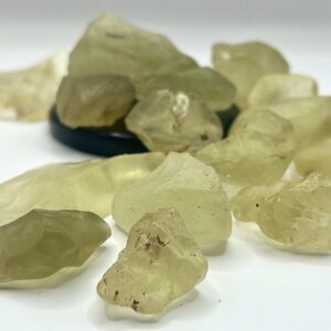 Pile of chunks of Libyan Desert Glass (pale yellow to translucent yellow) on a white background