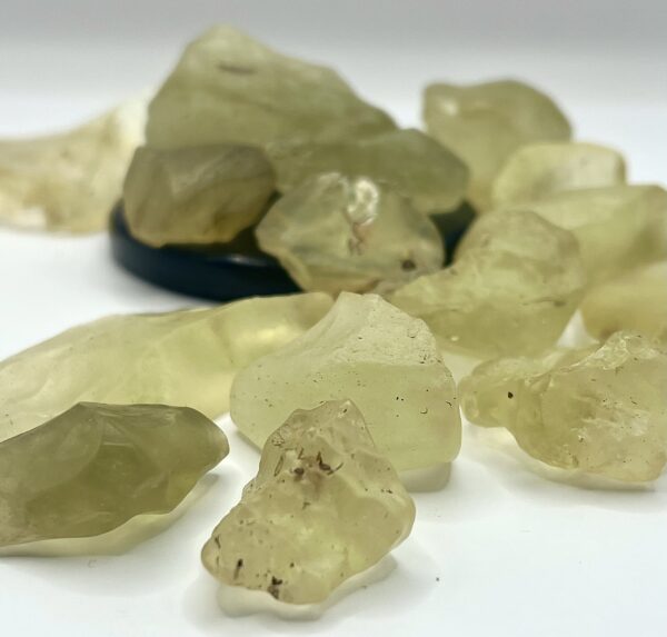 Pile of chunks of Libyan Desert Glass (pale yellow to translucent yellow) on a white background