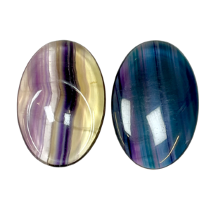 Two Fluorite Thumb Stones - clear with purple and green banding - on a white background