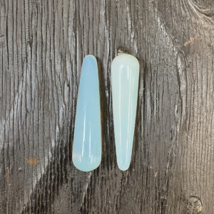Two Opalite Wands, transparent blue, on a black wooden board
