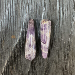 Two Banded Amethyst Wands, purple, lilac, white banding, on a black wooden board