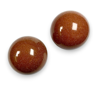 Two Goldstone spheres - brown stone with copper flecks - on a white background