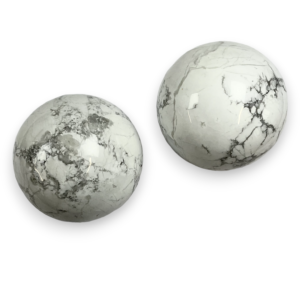 Two Howlite spheres - white stone with grey veining - on a white background