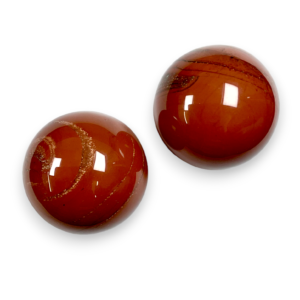 Two Red Jasper spheres - red stone with yellow banding - on a white background