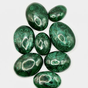 Group of Malachite Pebbles (green with dark green flowers and banding) on a white background
