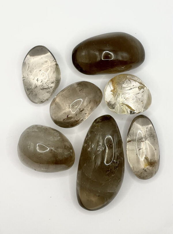 Group of Smoky Quartz Pebbles (transparent with dark areas of grey inclusions) on a white background