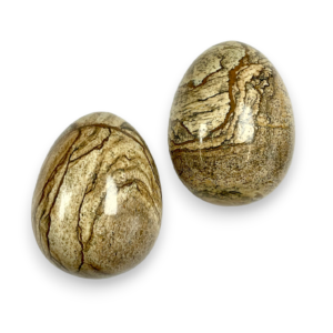 Two Kalahari Picture Stone eggs - beige stone with black veining - on a white background