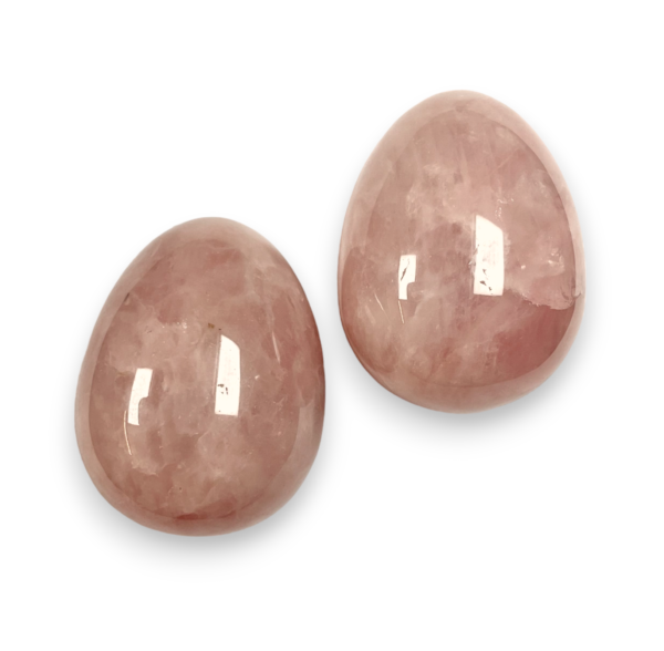 Two Rose Quartz eggs - pink stone - on a white background