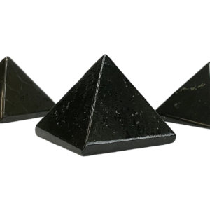 Three shungite pyramids - black with metallic veining - on a white background