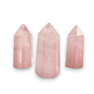 Three cut and polished points in an ascending line - pink rose quartz - on a white background