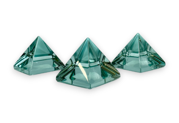 Three Blue Obsidian pyramids - transparent glass with a hue of turquoise - on a white background