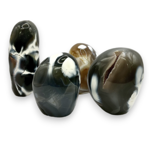 Group of domed freeforms - black stone with grey and white patches- on a white background