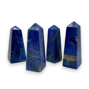 Four obelisks in a row - blue with gold banding and flecks lapis lazuli - on a white background