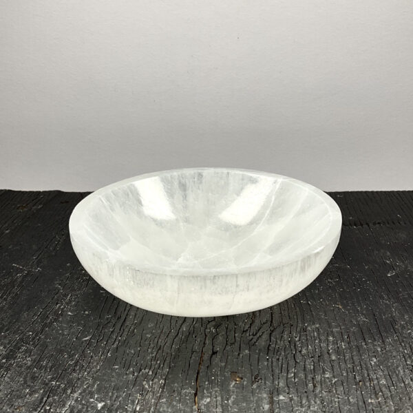 One Round Bowl (Small) - Selenite from the side - slightly translucent white bowls - on a dark wooden board