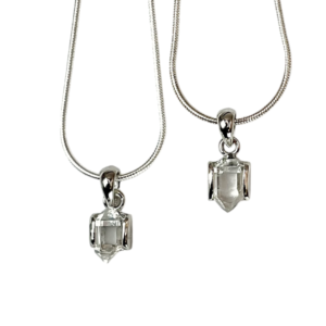 Two Herkimer AA Pendant - clear stone with points at both ends, hanging from a silver bail - on a white background