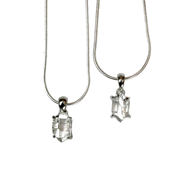 Two Herkimer AAA Pendant - clear stone with points at both ends, hanging from a silver bail - on a white background