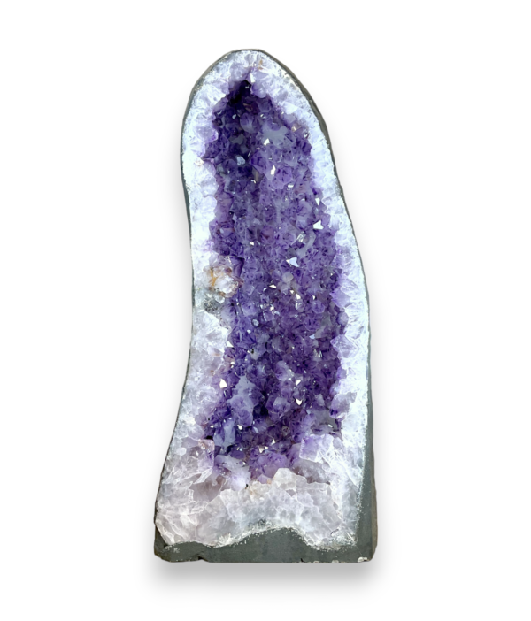 Amethyst Cave (3) shown from the front - half of a giant geode with purple points - on a white background