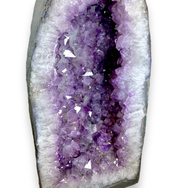 Amethyst Cave (E) close up - half of a giant geode with purple points - on a white background