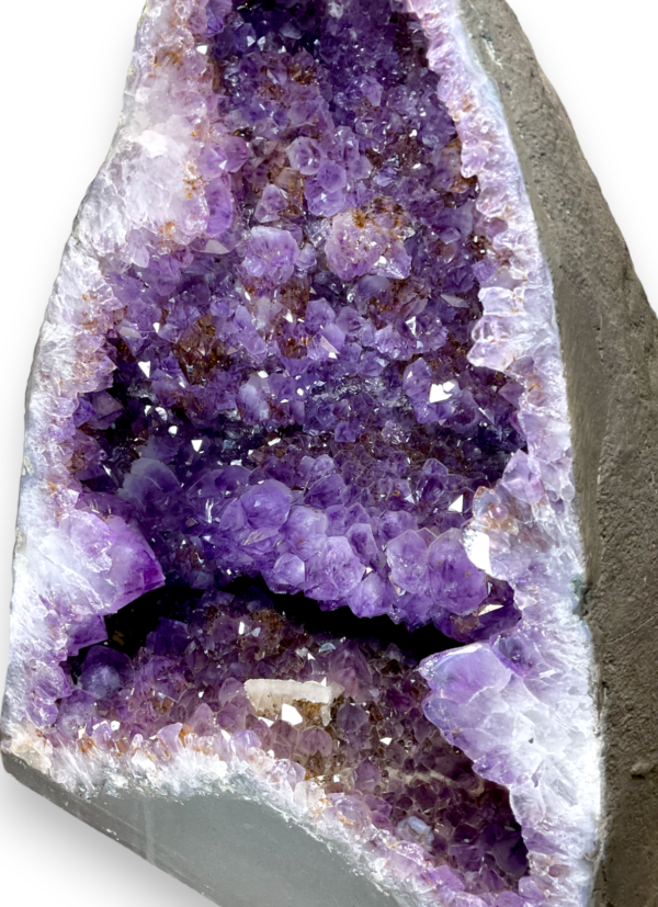 Amethyst Cave (H) close up - half of a giant geode with purple points - on a white background