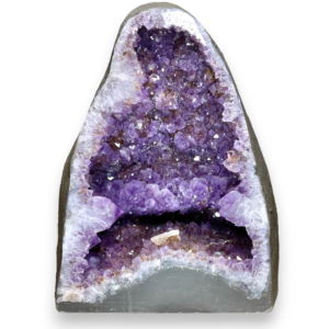 Amethyst Cave (8) shown from the front - half of a giant geode with purple points - on a white background