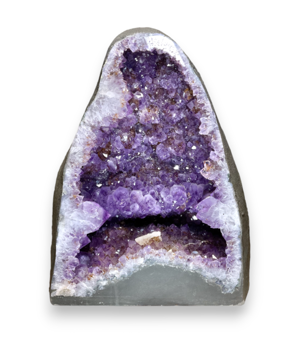 Amethyst Cave (8) shown from the front - half of a giant geode with purple points - on a white background