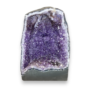 Amethyst Cave (9) shown from the front - half of a giant geode with purple points - on a white background