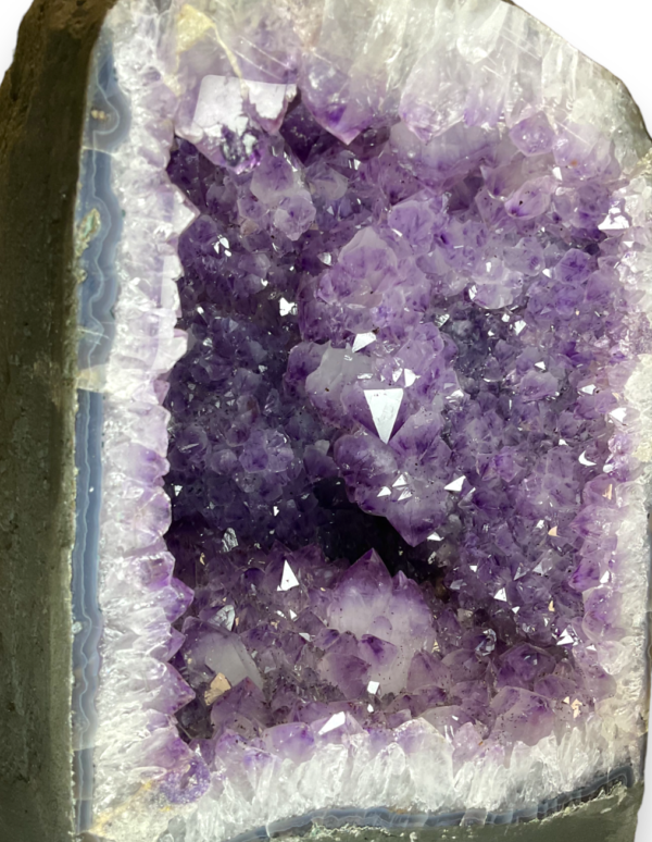 Amethyst Cave (J) close up - half of a giant geode with purple points - on a white background