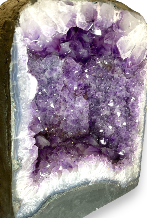 Amethyst Cave (K) close up - half of a giant geode with purple points - on a white background