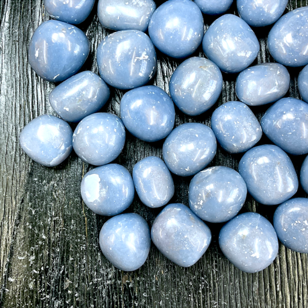 Example of Angelite (A Grade) tumble stone - pale blue, rounded stone - on a black background