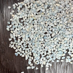 Example of Beryl (B Grade) - small chips of translucent pale blue tumble stone - on a dark wooden board