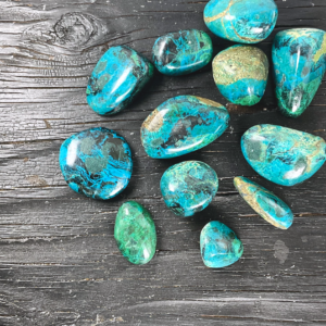 Example of Chrysocolla tumble stone - deep green and blue stone - on a black background