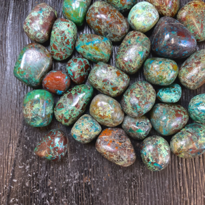 Example of Chrysocolla (Dark) tumble stone - deep green and blue stone with some areas of red - on a black background