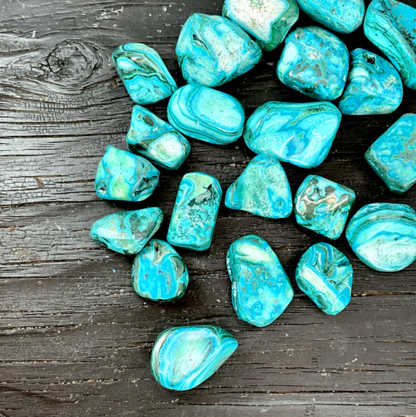 Example of Chrysocolla Malachite tumble stone - bright blue stone with swirling green banding and patterns - on a black background
