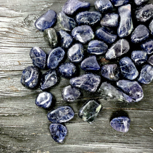 Example of Iolite (Dark) tumble stone - incredibly dark stone with shades of blue or purple - on a black background