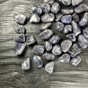 Example of Iolite (Light) tumble stone - incredibly dark stone with shades of blue or purple - on a black background