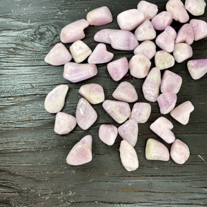 Example of Kunzite (A Grade) tumble stone - soft pink stone with areas of pale purple - on a black background